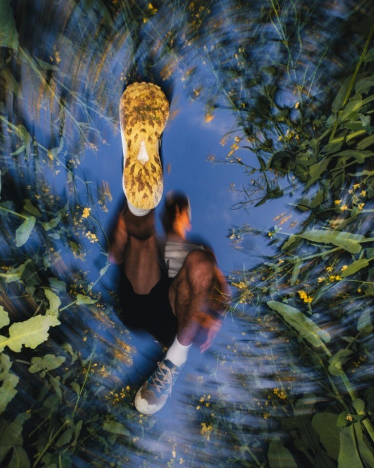 Homme assis dans un environnement naturel avec un éclairage artistique.